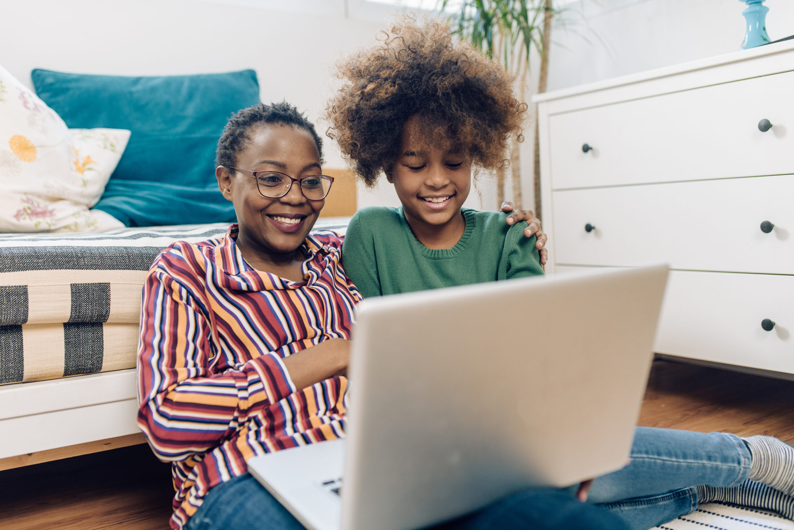 Happy African-American girl enjoying and shopping online with grandma